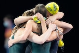 Australia's women's 4x100m medley relay team hug after the Commonwealth Games final.