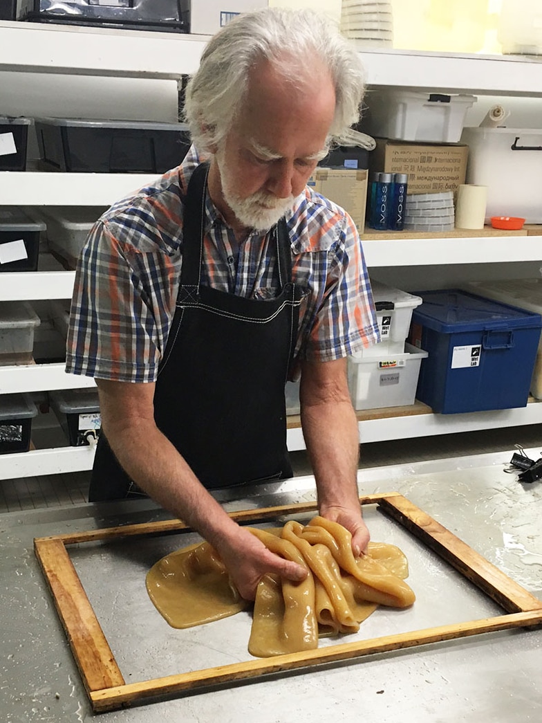 State Library scientist Dr Peter Musk works with the so-called 'vegan leather' made from kombucha tea