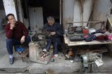 A Chinese cobbler repairs shoes