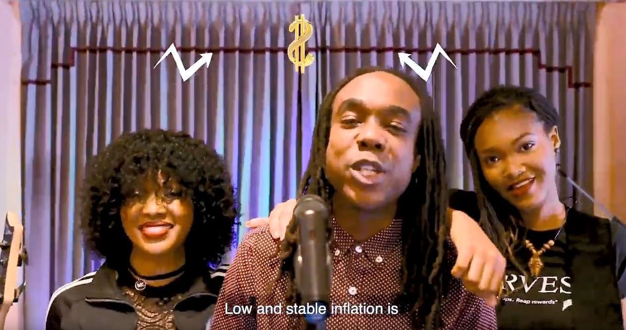 A man and two women in front of a microphone with dollar signs in graphics above their heads.