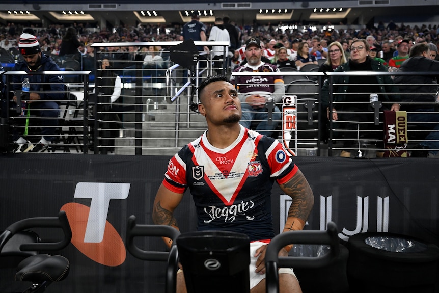 Sydney Roosters' Spencer Leniu on an exercise bike in front of fans at an NRL game in Las Vegas.