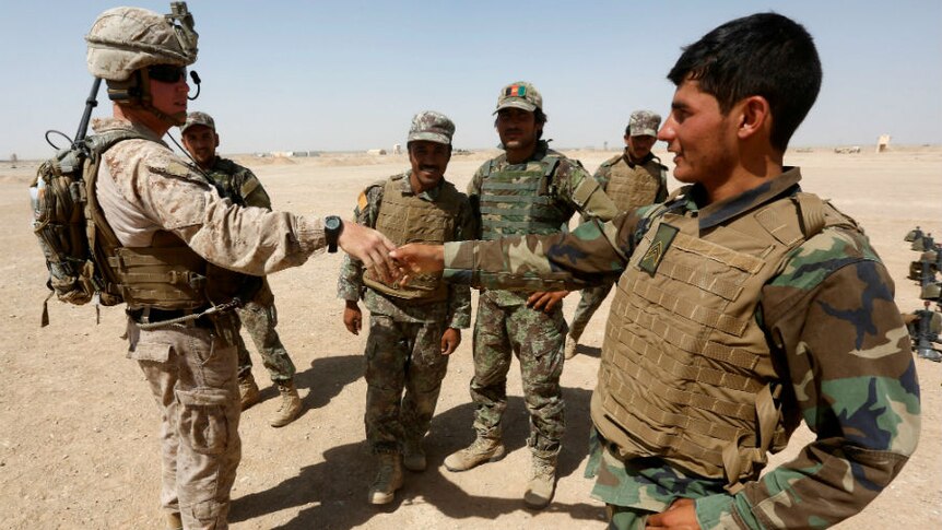 US Marine shakes hand with Afghan National Army soldiers in the desert