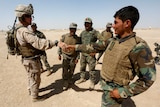 US Marine shakes hand with Afghan National Army soldiers in the desert