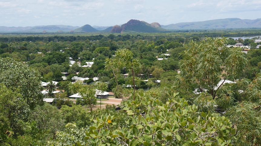 view of town with plenty of wet season green and red rock ranges in the distance