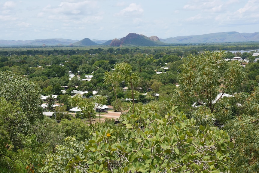 view of town with plenty of wet season green and red rock ranges in the distance