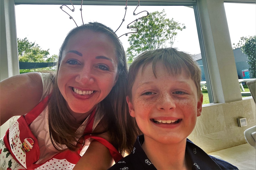 A woman and a boy smiling at the camera