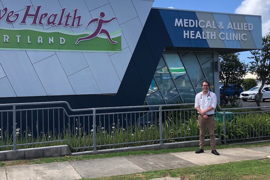 Man in front of new building large sign says active health portland medical and allied health clinic