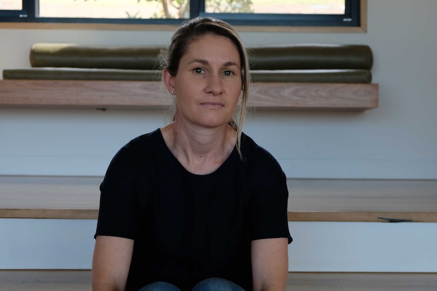 Jane Fleming sits on steps inside her house.