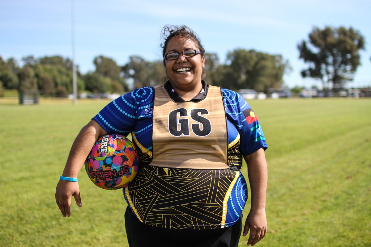 Luana Muir 29, Team Beyond Blue from Ballarat, has lost five members of her family to suicide, stands holding a ball.