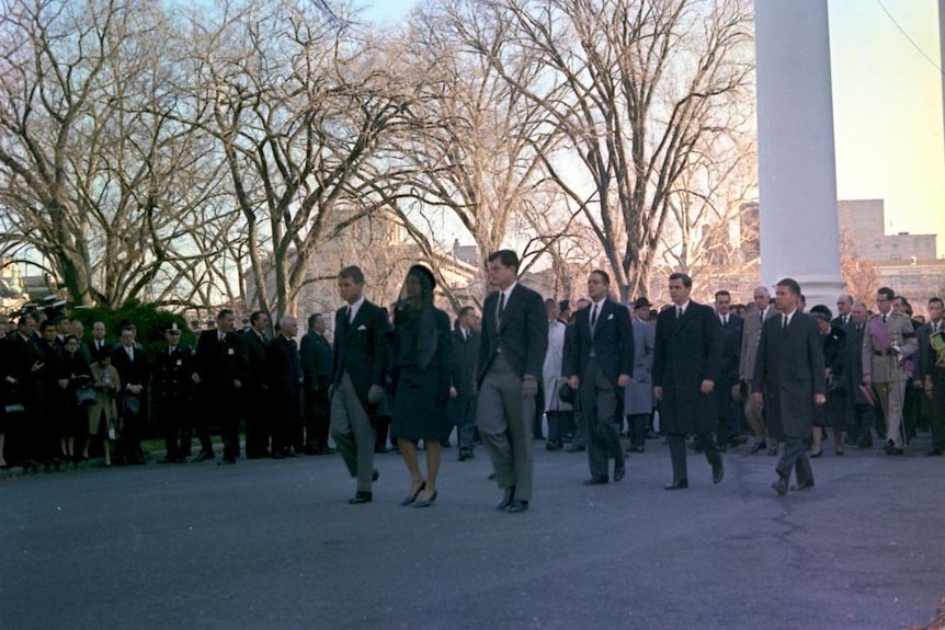 Members of the Kennedy family lead the funeral procession for JFK from the White House.