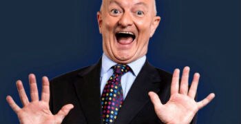 Antony Green looks at the camera with his mouth open while waving his hands.