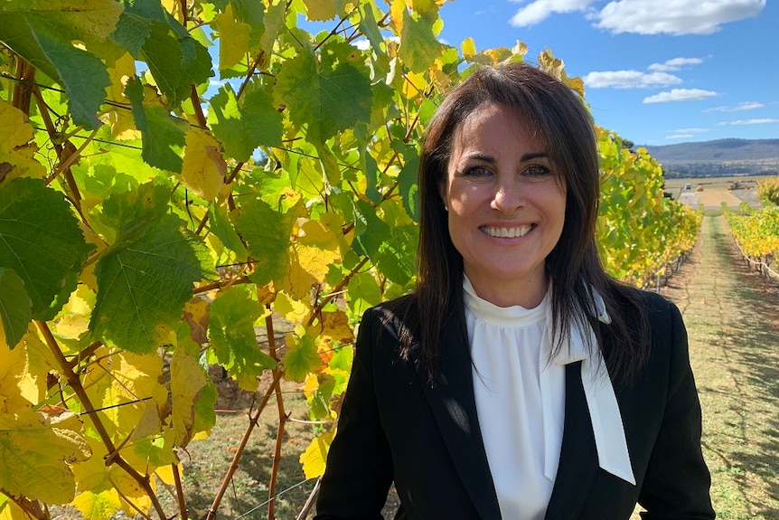 The new Tasmanian Primary Industries and Water Minister Jo Palmer smiling at the camera in a vineyard at Legana