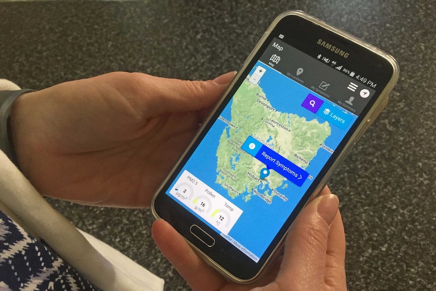 Hand holds a smartphone showing AirRater app detecting air quality.