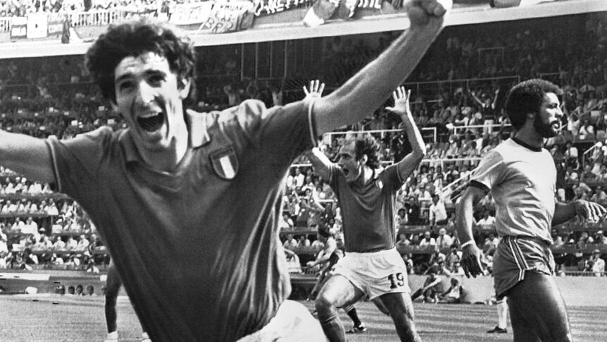 Paolo Rossi runs with his hands in the air and mouth open in a black and white photo