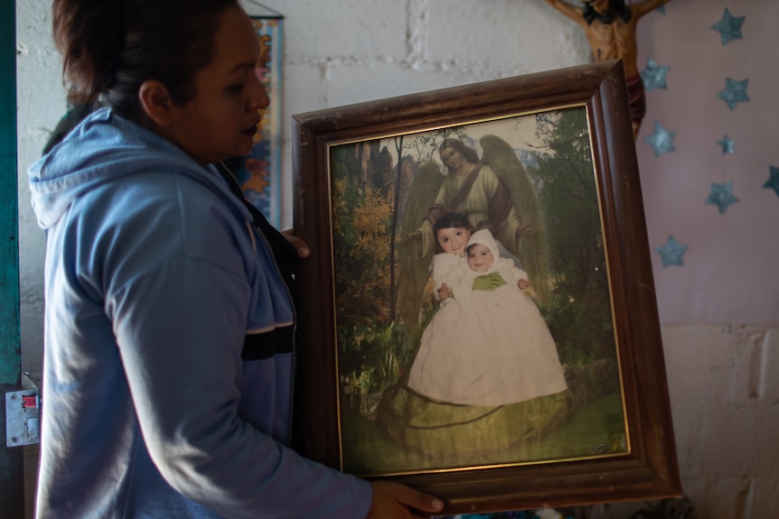 Angeles holds a portrait of Melany.