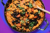 A pot of baked puttanesca risotto topped with chopped chilli, olives and parsley, a one-pot dinner recipe.