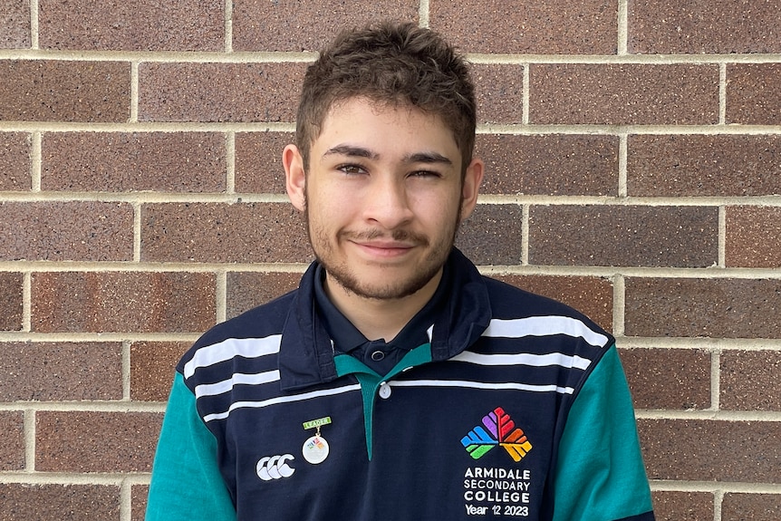 Jacob in high school uniform, smiling at the camera.