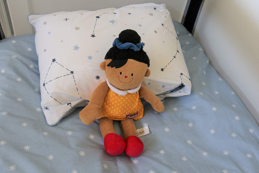 A doll sits on the bed at a family unit at Logan House at Chambers Flat.