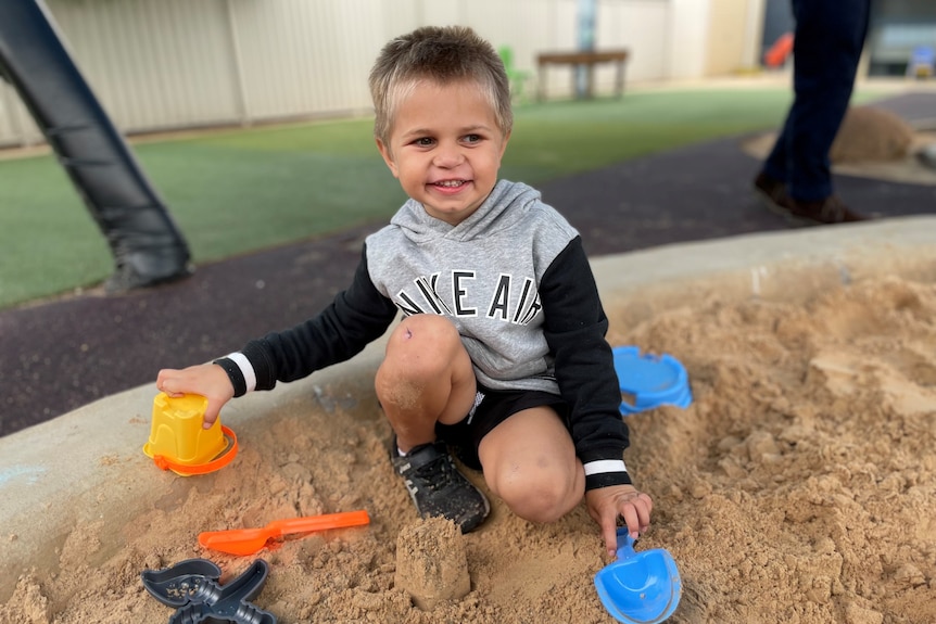 A cute little boy in a sandpit