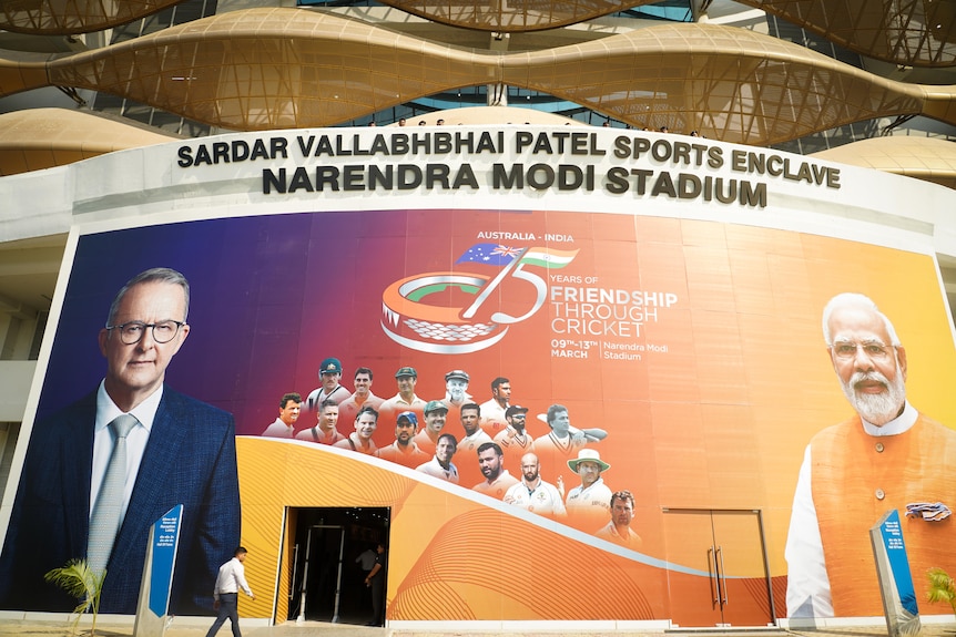 A large billboard underneath a sign for NARENDRA MODI STADIUM features Anthony Albanese and the Indian PM