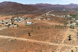 A small town from the air surrounded by red soil and hills