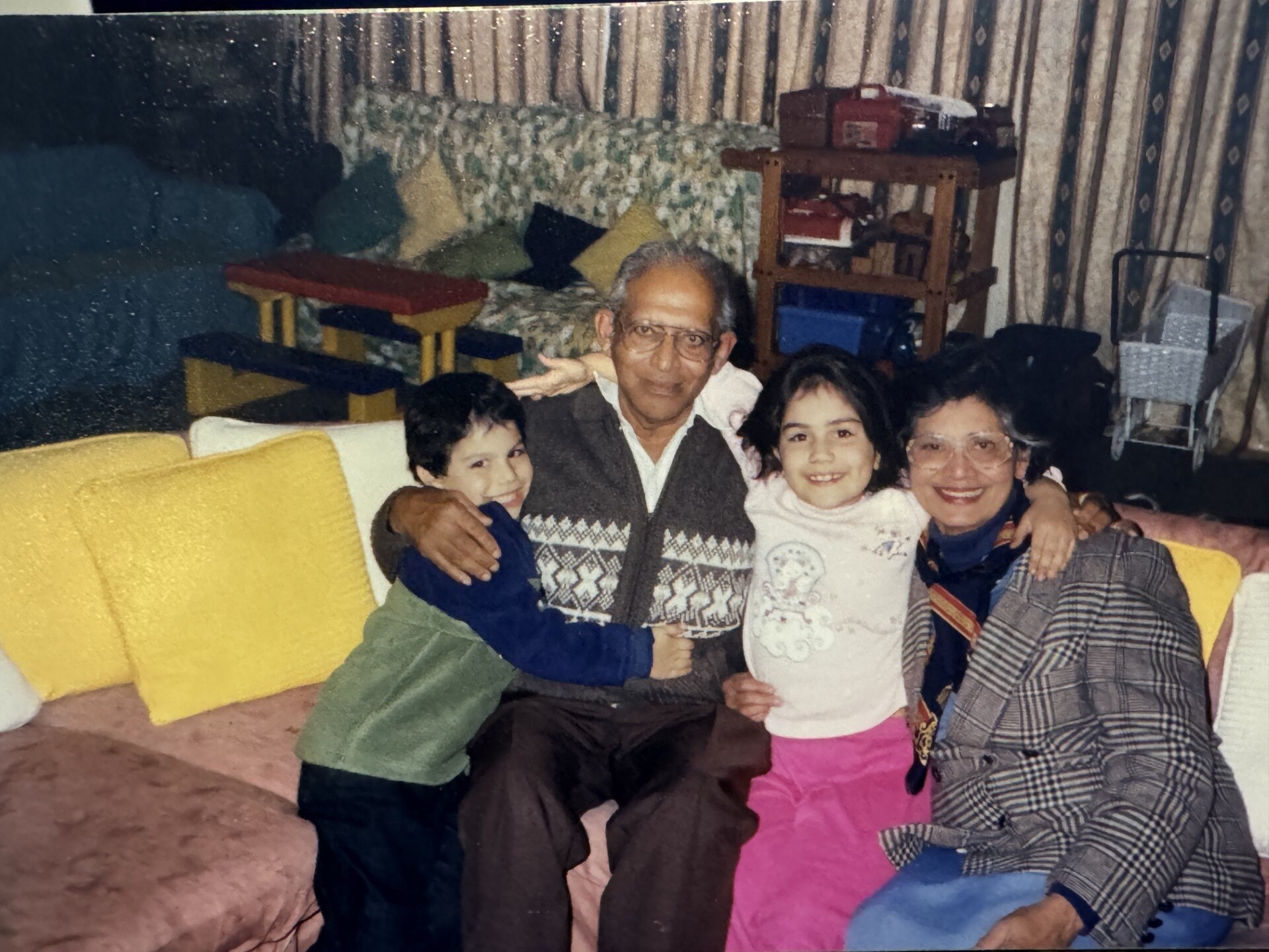 A man, woman, boy and girl hold each other as they pose for a photo.