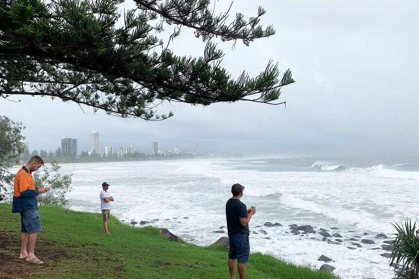 People look at the huge swell at Burleigh during wild weather.