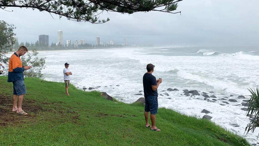 People look at the huge swell at Burleigh during wild weather.