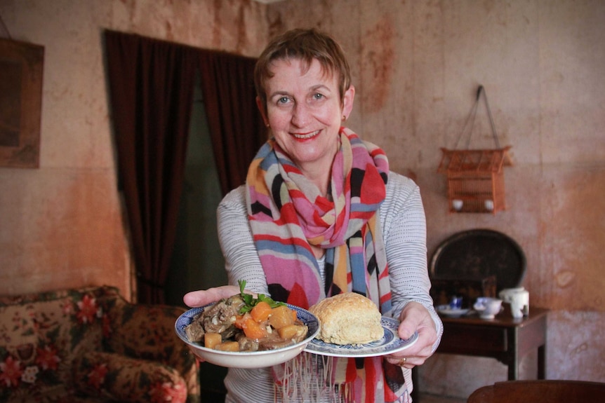 Sydney Living Museums' resident colonial gastronomer Jacqui Newling holding a bowl of stew and some Irish soda bread.