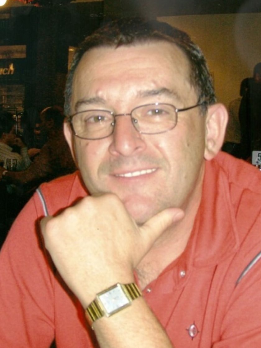 Man with glasses and gold watch looking into camera
