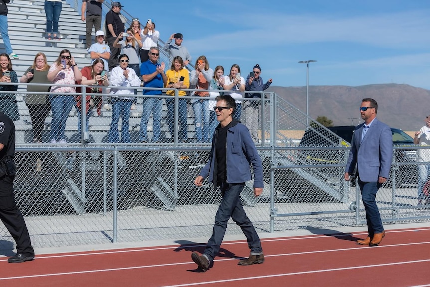 Kevin Bacon walks out onto the school sportsground at Payson High School. 