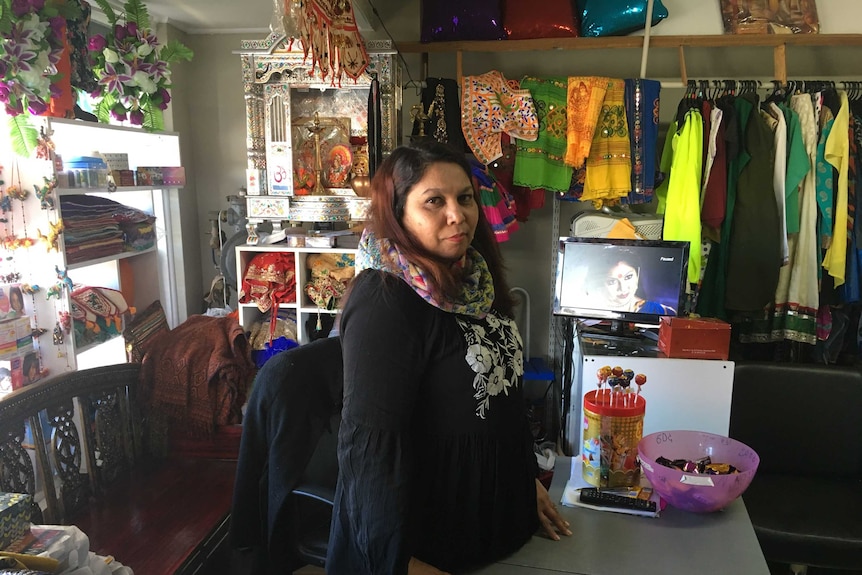 A woman in a shop with Indian groceries, clothes and goods