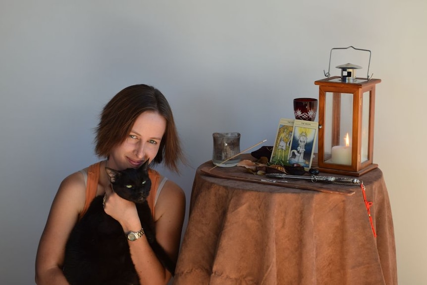 Sarah Betts sits next to her Pagan altar in her home.