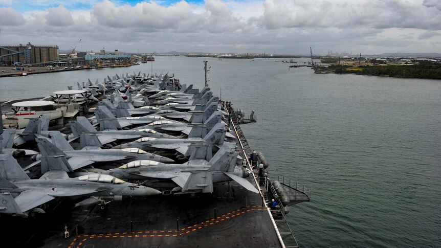 Dozens of aircraft line the USS Ronald Reagan while docked in the Brisbane River.