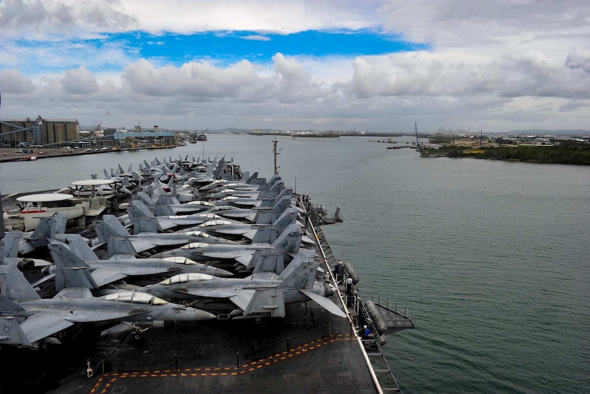 Dozens of aircraft line the USS Ronald Reagan while docked in the Brisbane River.