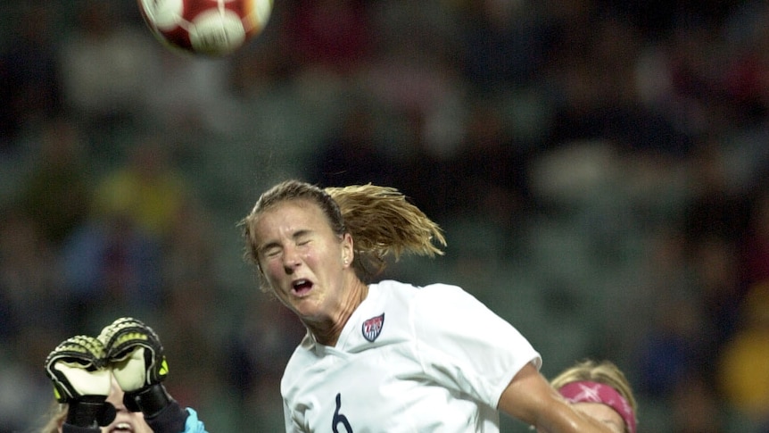 Brandi Chastain of the United States wins a header against Norway at the Sydney Olympics in 2000.