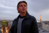 Man looking skyward with Eiffel Tower in background