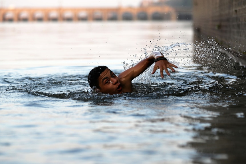 A boy swims in a river