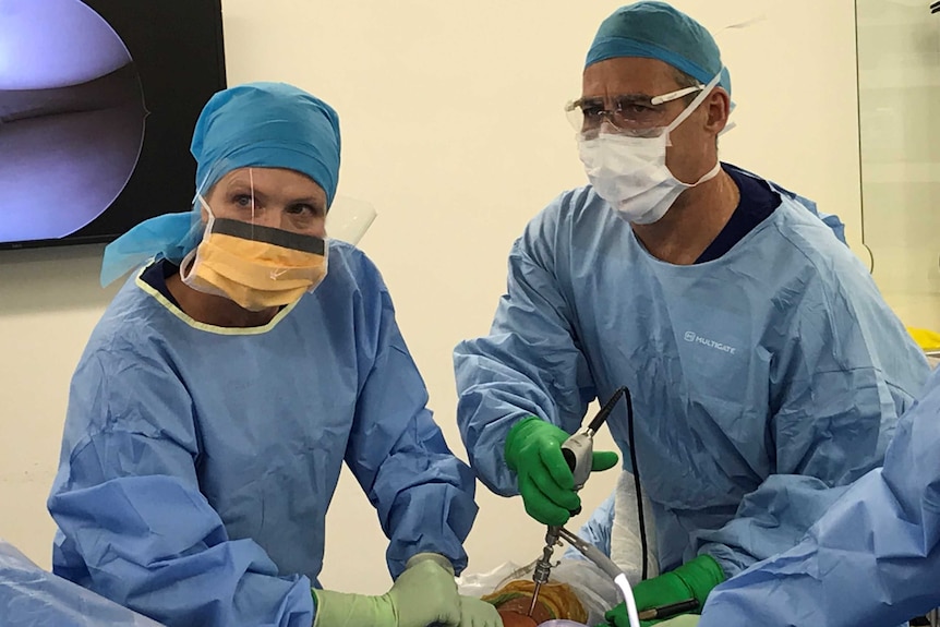 Dr Christopher Vertullo performs a knee operation assisted by a nurse