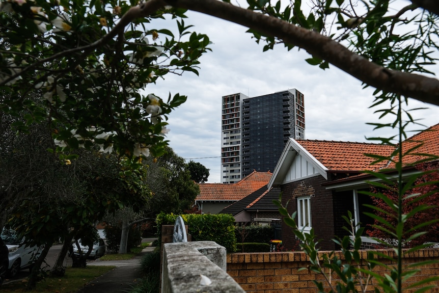 An old house with an apartment block in the background