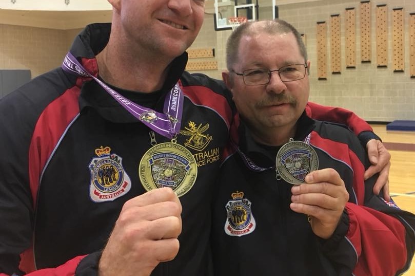 Picture of two men holding their medals.
