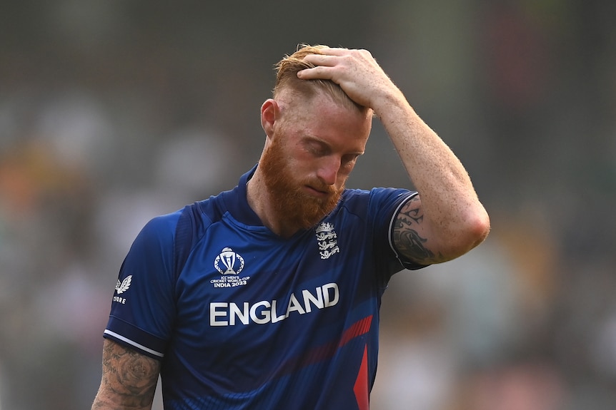 Ben Stokes holds his head and looks down puffing out his cheeks