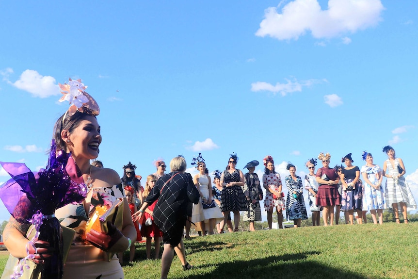 Women lined up for fashion on the field in their best race outfits and head pieces