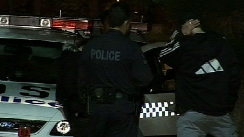 Police speak to a man outside the scene of the shooting on Gray Street in Kogarah.