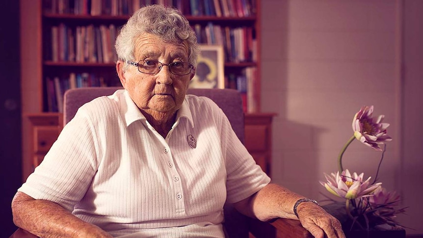 Sister Anne Gardiner sits in a chair in a lounge room.