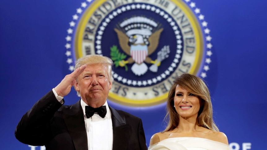 US President Donald Trump salutes with his wife Melania