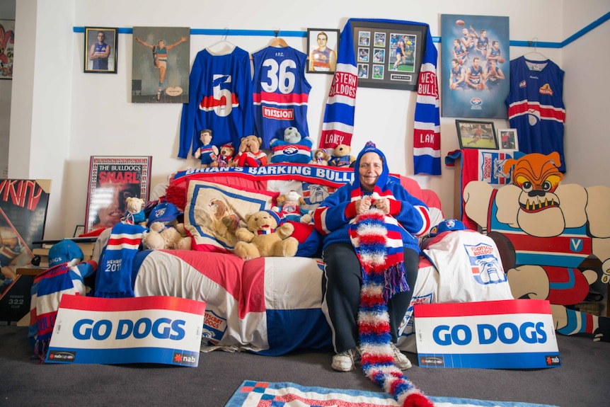 Marie Mackellin sits in her western bulldogs themed home, surrounded by memorabilia of the team.