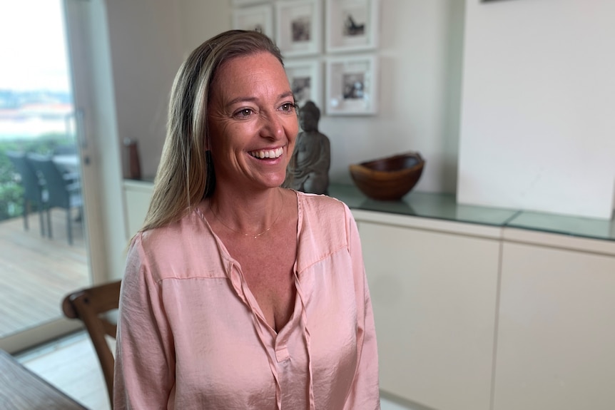 A woman in a pink top smiling