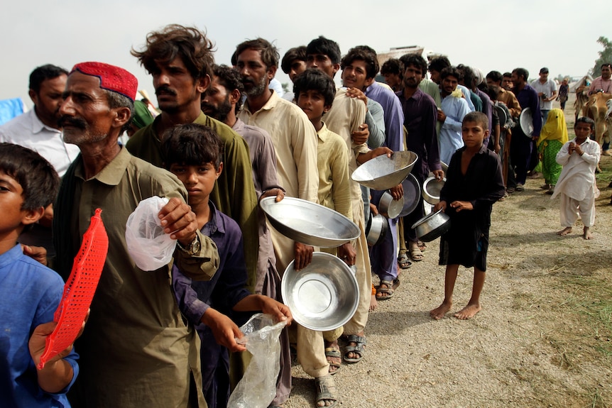 Des gens font la queue pour recevoir de la nourriture de l'armée dans un Pakistan touché par les inondations.