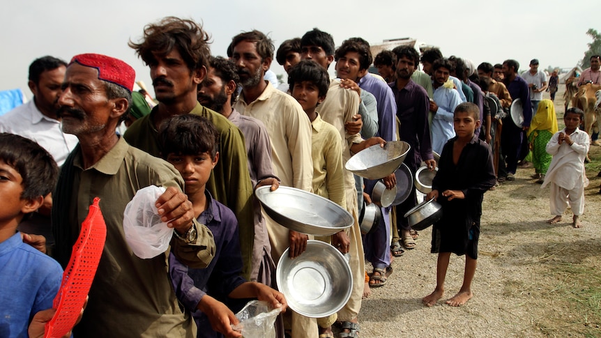 People stand in line waiting for food from the army in flood-hit Pakistan.